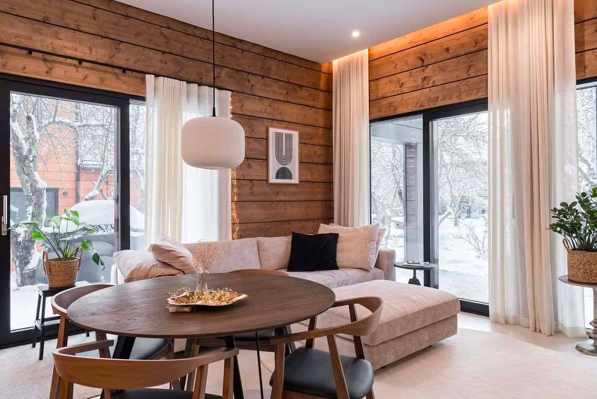 Un salon moderne et chaleureux avec des downlights LED LedStore.fi qui mettent en valeur les surfaces en bois et l'architecture de l'espace.