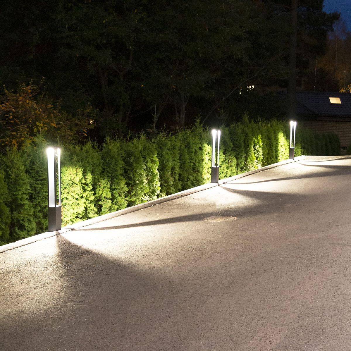 Des colonnes lumineuses en bordure de parcelle éclairent la cour.