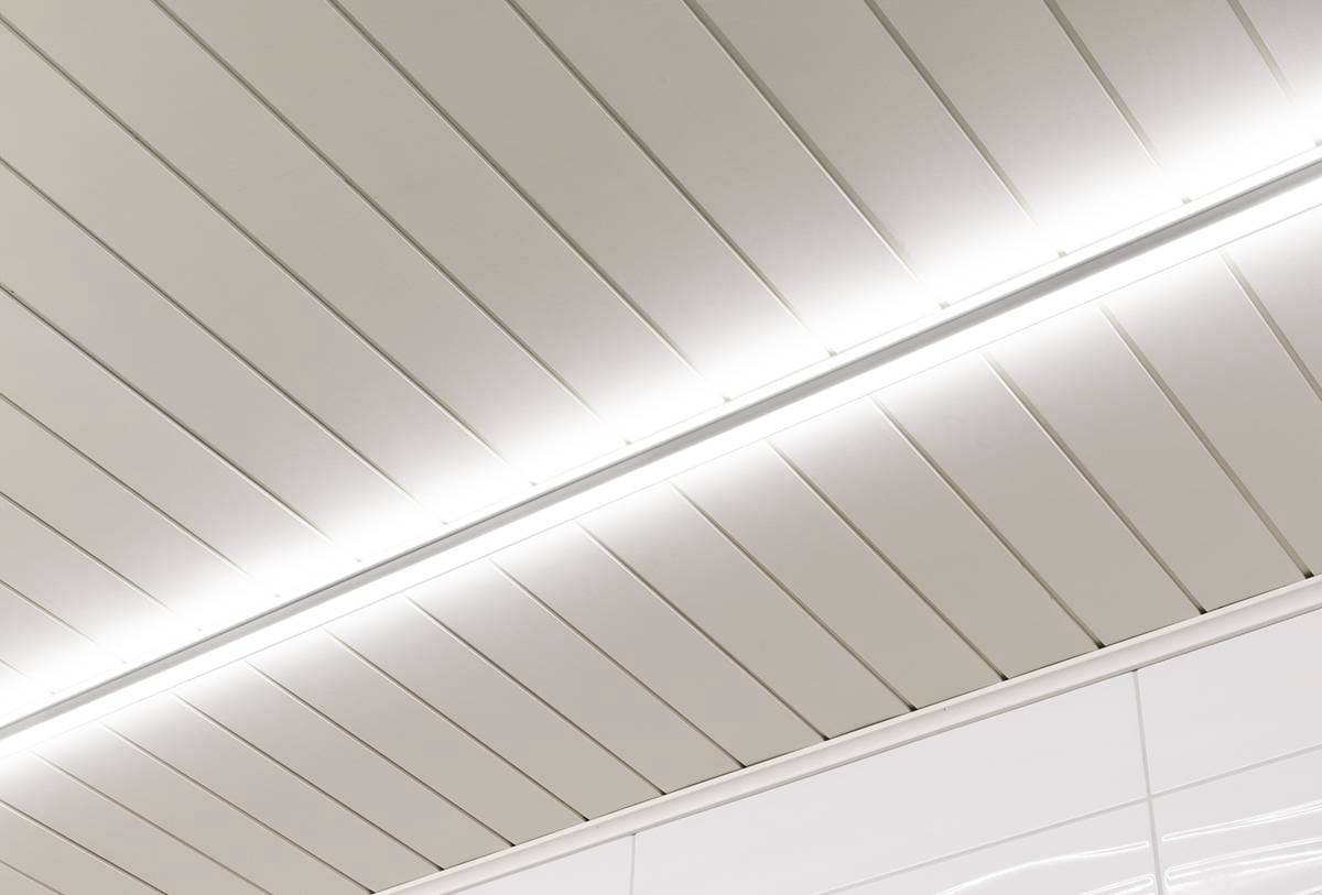 LedStore.fi propose des plafonniers modernes qui comprennent des panneaux parallèles animés par une bande lumineuse centrale à LED. La surface lisse des panneaux rectangulaires répond parfaitement à l'esthétique épurée et minimaliste de l'espace.