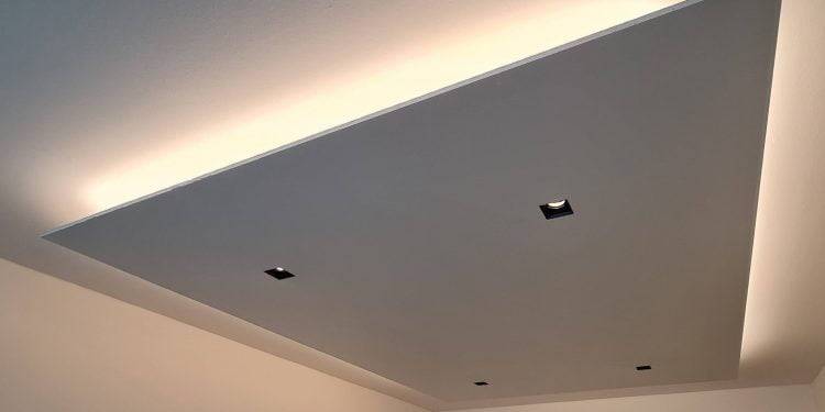 Une solution de plafond moderne avec un panneau rectangulaire encastré avec quatre luminaires LED carrés. Les bords du panneau brillent doucement, créant un éclairage subtil sur le plafond et les murs pour un look contemporain. Vous trouverez ce style dans la large gamme d'éclairage LED de LedStore.fi.
