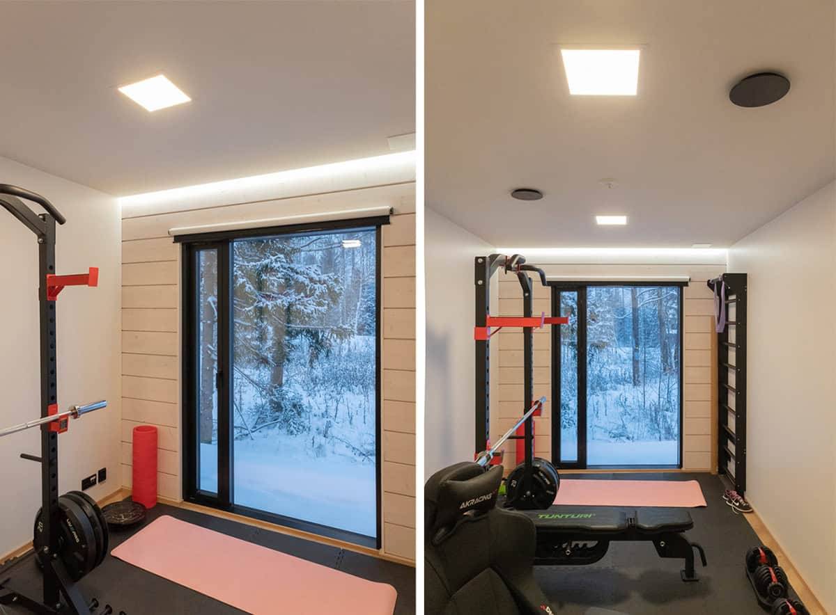 Un petit gymnase avec une grande fenêtre donnant sur l'extérieur, deux petits panneaux lumineux au plafond et une bande LED au-dessus de la fenêtre.