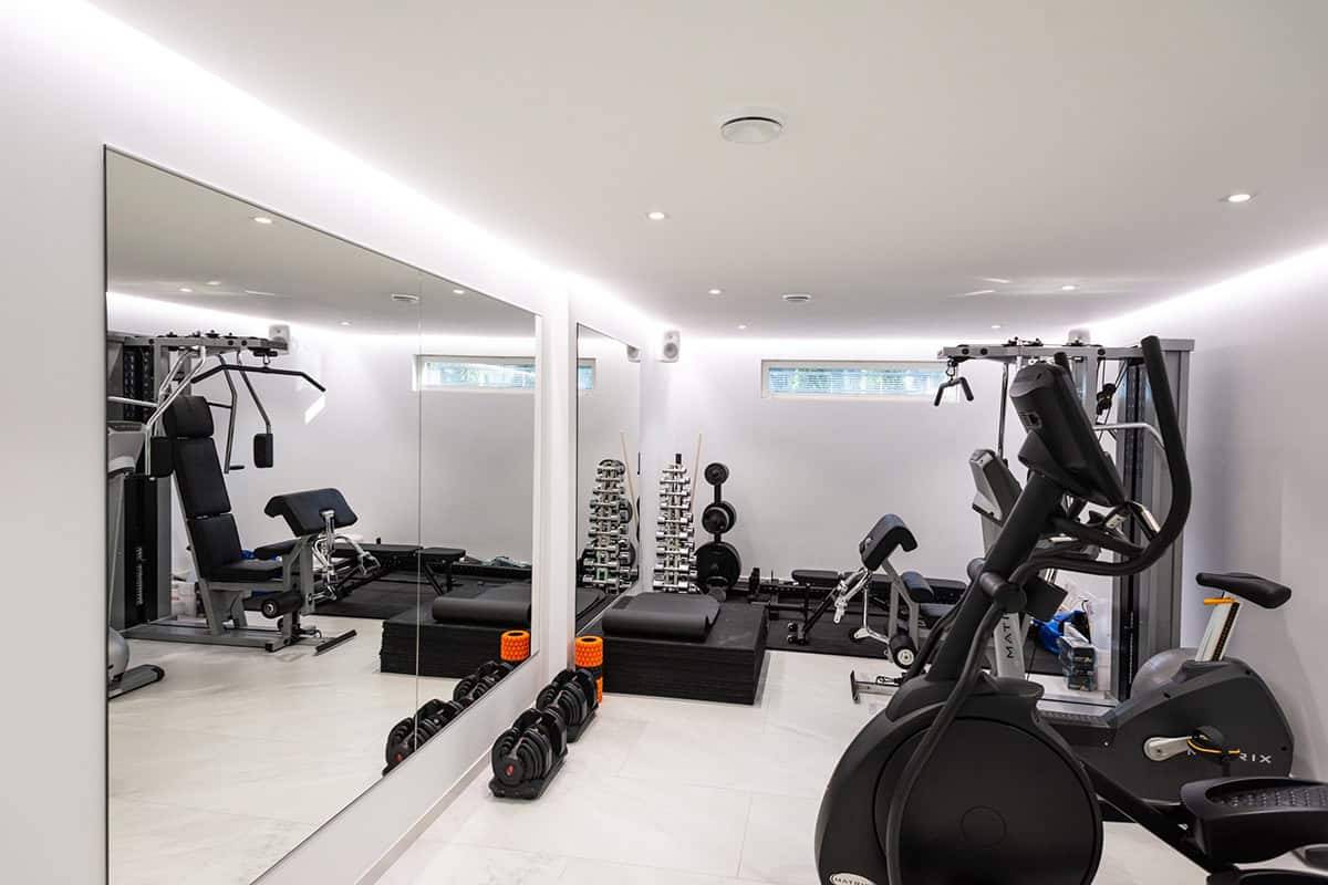 Une petite salle de sport avec des bandes lumineuses LED et des projecteurs.