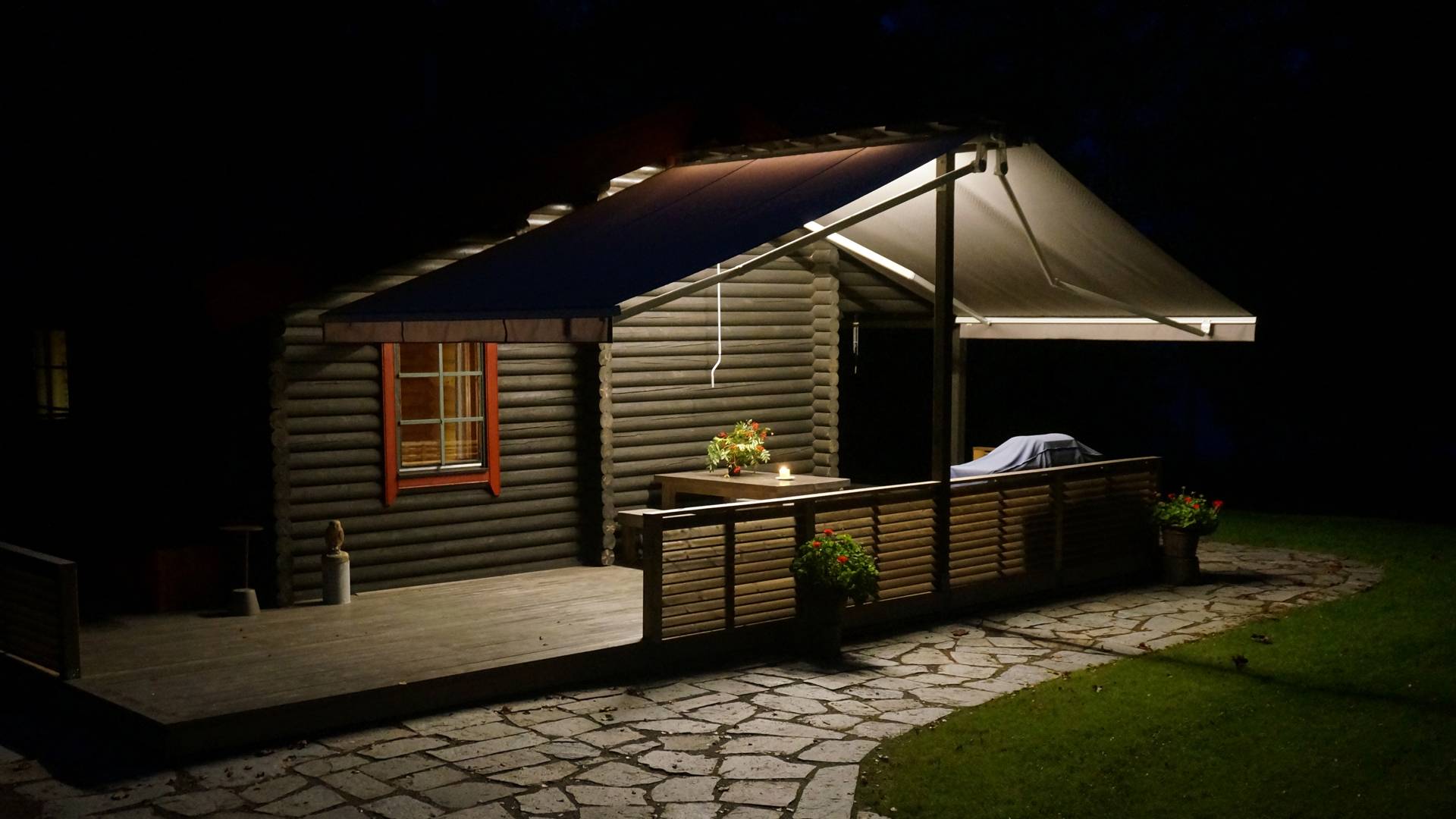 Des bandes lumineuses LED fixées sous l'auvent éclairent la surface de la terrasse et l'allée pavée vers le bas. La lumière n'est pas réfléchie vers le haut.