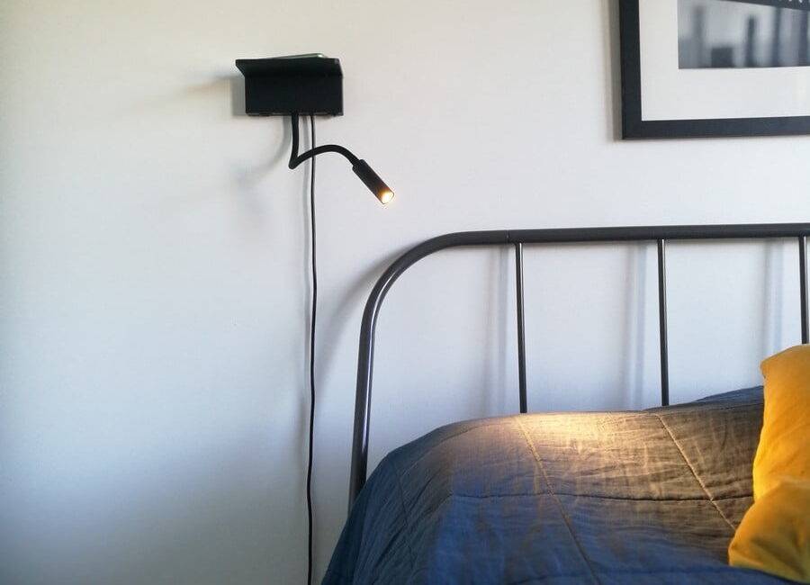 Lampe de nuit et de lecture NIGHT à la tête du lit. La lampe est dotée d'un système de recharge sans fil et d'un port USB pour recharger votre téléphone.  Ledstore.fi