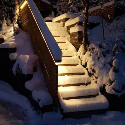 Les escaliers extérieurs enneigés reflètent la lumière de la balustrade.