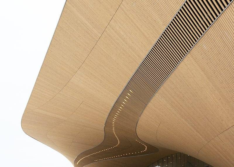 Une texture de bois courbée avec un design ondulé et des lumières LED encastrées qui accentuent l'aspect abstrait moderne sur un fond blanc.