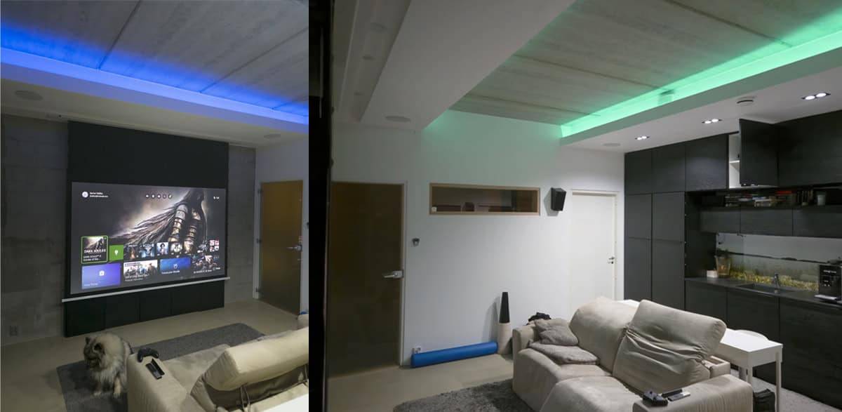 Salon moderne avec éclairage LED LedStore.fi pour home cinéma, écran de projection, sièges confortables et un chien sur le sol.