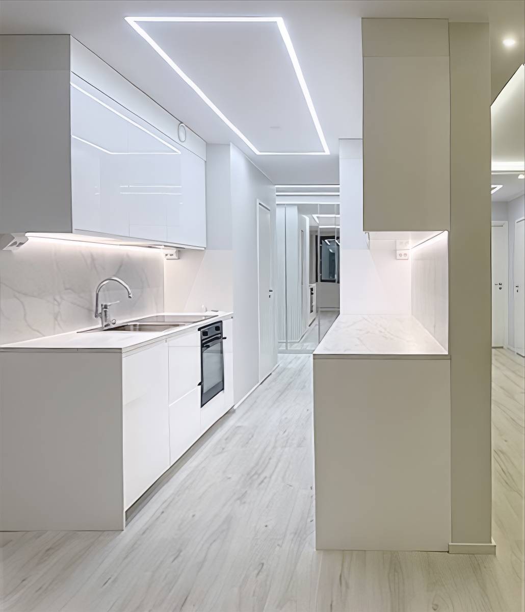 Éclairage du plan de travail de la cuisine par une bande LED et éclairage général créé par une bande LED montée sur un profilé d'aluminium encastré.