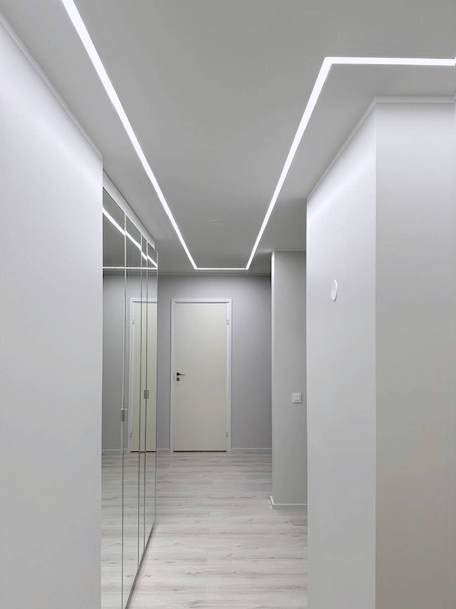 L'éclairage encastré par bandes LED dans le couloir se prolonge de manière transparente dans le corridor.